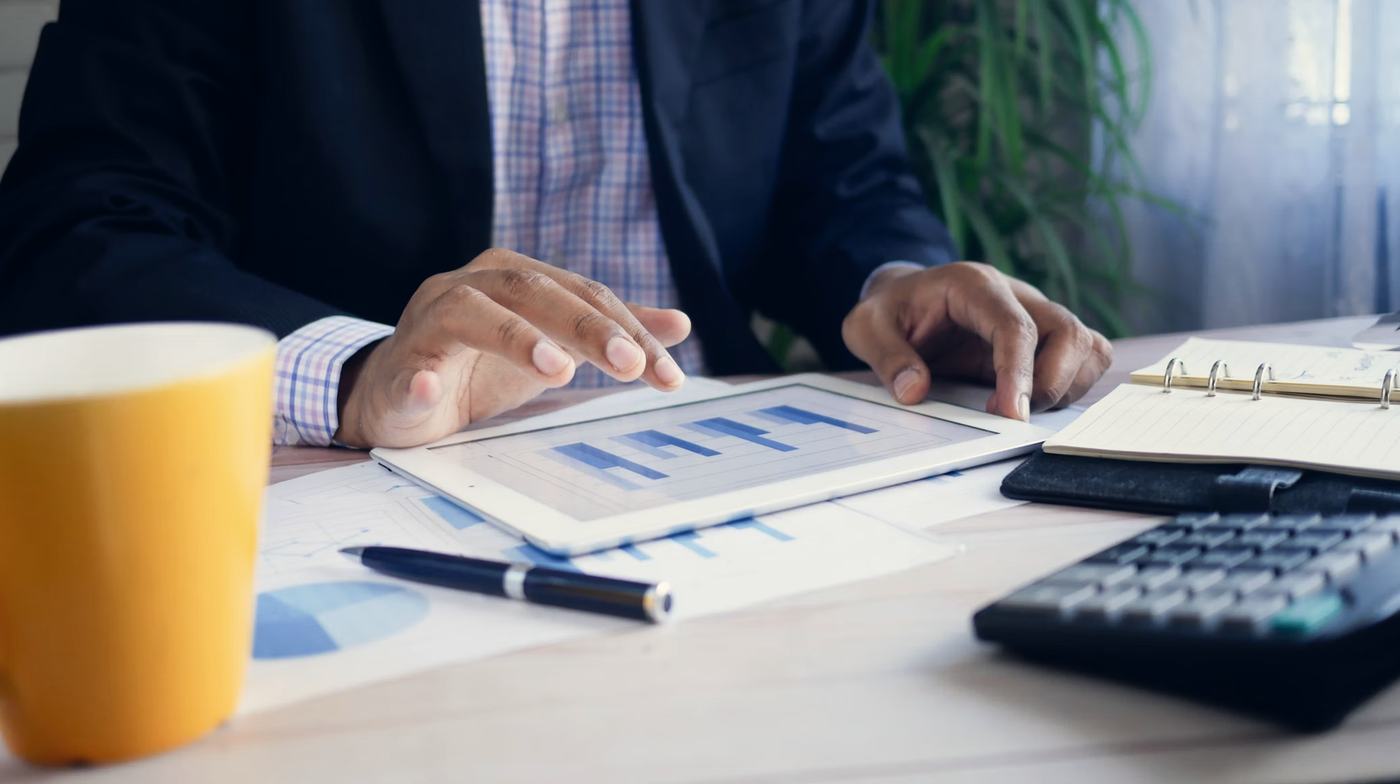 An advisor reviews financial charts on a tablet at a desk